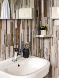 a bathroom with a white sink and a wall at 'Villager' the Yurt at Pentref Luxury Camping in Penuwch