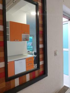 a mirror reflecting a kitchen with a counter and cabinets at Apartmani Sladojević in Mrkonjić Grad +34 photos