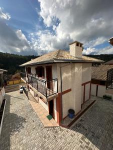 a small house with a balcony on a roof at Pousada Requinte da Serra in Monte Verde