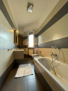 y baño con bañera, aseo y lavamanos. en Eur Centro lux apartment con camino, en Roma