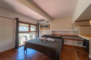 ein Schlafzimmer mit einem Bett mit einem ausgestopften Tier darauf in der Unterkunft Claudia's home 2 in Alghero