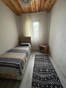 - 2 lits dans une chambre avec une fenêtre et un tapis dans l'établissement Ayliya köy evi, à Akcaabat