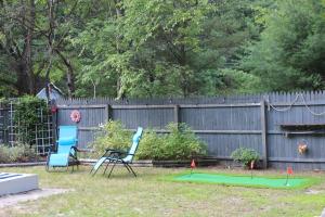 dos sillas y un putting green en un patio en Cozy cottage just minutes from Lake Michigan! en Pentwater