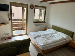 a bedroom with a bed and a couch and a window at Appartamento vacanza Top Residence in Passo del Tonale