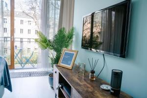 een woonkamer met een tv aan een blauwe muur bij PLATER PREMIUM APARTMENTS in Warschau