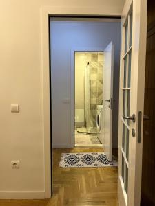 a door leading to a bathroom with a shower at YellowHouse in Prishtinë