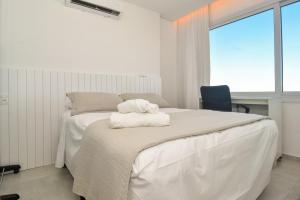 - une chambre avec un lit et des serviettes dans l'établissement Requinte com Vista Mar na Avenida Atlântica P2178, à Balneário Camboriú