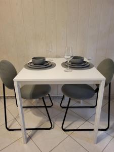 una mesa blanca con sillas, platos y copas de vino en Old Town Sedlar Apartment en Split