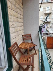 two wooden chairs sitting on a balcony at Old Town Sedlar Apartment in Split