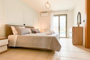 a bedroom with a bed and a large window at Saint Georgio Castle View Villa in Argostoli
