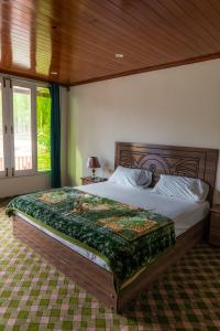 Schlafzimmer mit einem großen Bett mit einem Kopfteil aus Holz in der Unterkunft Greenwood Resort Skardu in Skardu