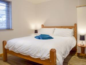Un dormitorio con una gran cama blanca con una toalla azul. en Lletyr Saer, en Pen-y-bont-fawr