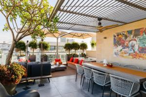 a patio with a table and chairs in a building at Luxe 3BR Penthouse w Jacuzzi&Parking&Mamad by HolyGuest in Tel Aviv