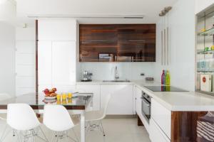 a kitchen with white cabinets and white stools at Luxe 3BR Penthouse w Jacuzzi&Parking&Mamad by HolyGuest in Tel Aviv