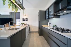 uma cozinha com armários a preto e branco e um lavatório em Villa Oxy Private Pools & Seaview & Heated Indoor Pool em Göcek