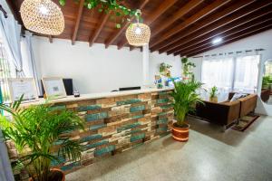 una oficina con una pared de ladrillo con plantas en ella en Spring Hostel en Medellín