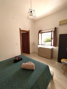 een slaapkamer met een groen bed en een raam bij Da Miky Casa Vacanze Teulada Sud Sardegna in Teulada
