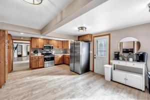 a kitchen with wooden cabinets and a stainless steel refrigerator at Mader Haven Across from the Lake home in Shawano
