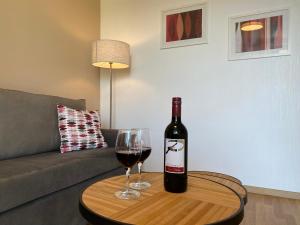 una botella de vino y una copa en una mesa en Pension Peterhof, en Mörbisch am See