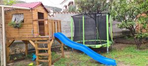 a playground with a slide and a play house at Guesthouse Tariba in Supetarska Draga