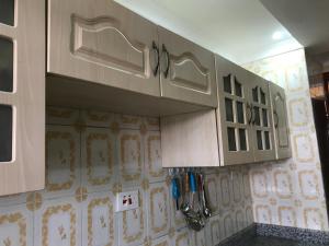 a kitchen with white cabinets on the wall at Maliaways Comfy Airbnb-Jkia in Nairobi