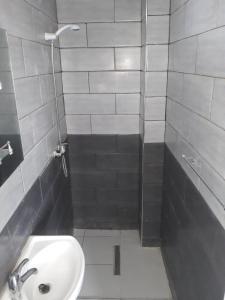 La petite salle de bains est pourvue d'un lavabo et d'une douche. dans l'établissement Immeuble THALA Tigzirt appart 90m2, à Tigzirt