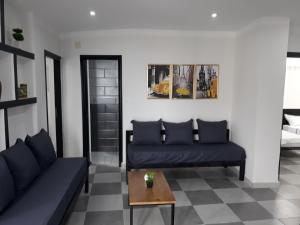 - un salon avec deux canapés bleus et une table dans l'établissement Immeuble THALA Tigzirt appart 90m2, à Tigzirt