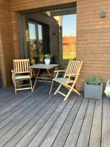 2 sillas y una mesa en una terraza de madera en Pirtis su nakvyne dviem en Kaunas