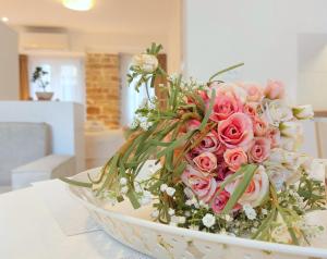 a bouquet of pink roses in a bowl on a table at Mouses Erato in Vathi, Ithaka