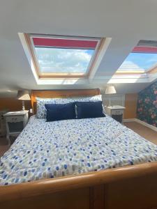 una camera da letto con un grande letto con due finestre di ByTheSea a Malahide