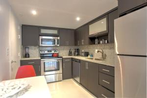 a kitchen with gray cabinets and a white refrigerator at Miami Hollywood Gorgeous 2BD Awesome Ocean View in Hollywood