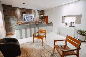a living room with two chairs and a counter at Hotel Kanaan in Pimenta Bueno