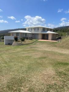 a large white house with a large yard at Villa Maxim vue sur mer in Fond Boucher