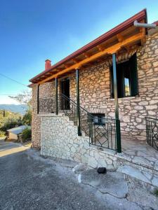 a stone building with a balcony on the side of it at Πέτρινο εξοχικό στο Δάρα in Daras