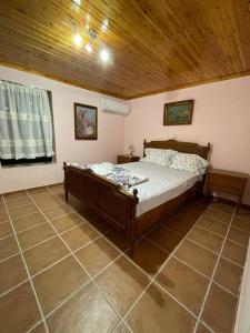 a bedroom with a bed and a wooden ceiling at Πέτρινο πολυτελές εξοχικό in Daras