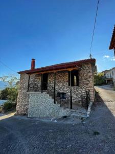 a small stone house with a gate on a street at Πέτρινο εξοχικό στο Δάρα in Daras +6 photos