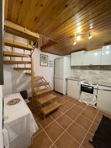 a kitchen with a wooden ceiling and a staircase in it at Πέτρινο πολυτελές εξοχικό in Daras