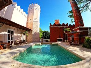 a pool in front of a house with a tower at Hacienda San Antonio Millet in Tixkokob
