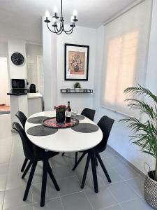 a dining room with a white table and black chairs at Art-Apart Caronte in Riviera del Sol, Mijas Costa in Mijas Costa +27 photos