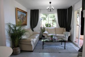a living room with two couches and a table at Art-Apart Caronte in Riviera del Sol, Mijas Costa in Mijas Costa