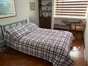 uma cama com um cobertor xadrez num quarto em CHARLIE'S HOUSE em Bogotá