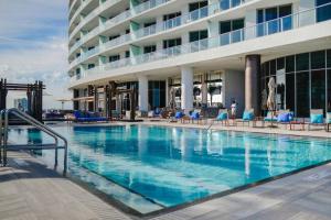 a large swimming pool in front of a hotel at Gorgeous Views Await in Your Beachfront Condo in Hollywood