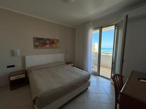 a bedroom with a bed and a view of the ocean at Bikini Hotel in Vieste