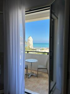 a balcony with a table and a view of the ocean at Bikini Hotel in Vieste