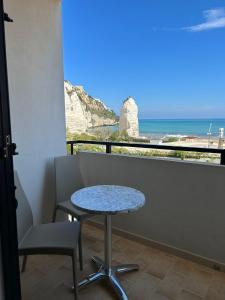 a table and chair in a balcony with a view of the ocean at Bikini Hotel in Vieste
