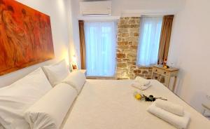a bedroom with a white bed with towels on it at Mouses Erato in Vathi, Ithaka