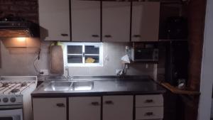 cocina con fregadero, fogones y ventana en Monoambiente interno en Trelew en Trelew