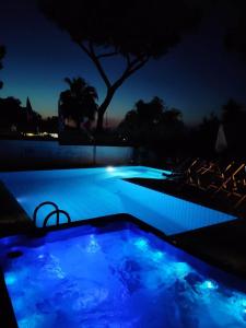 una piscina por la noche con luces azules en Villa Cinque Pini, en Isquia