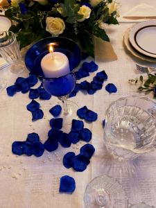 a candle and blue petals on a table at Villa Aurora in Mandatoriccio Marina