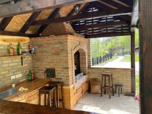a kitchen with a brick oven with a table and chairs at Kuca za odmor Marjanovic in Gornji Milanovac